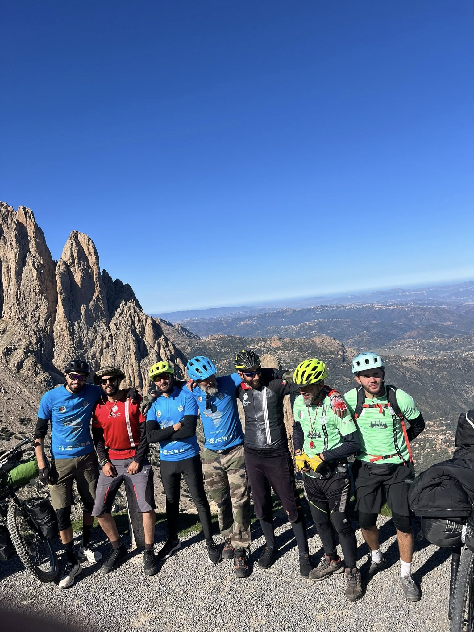 Cyclists at mountain summit with dramatic rock formations